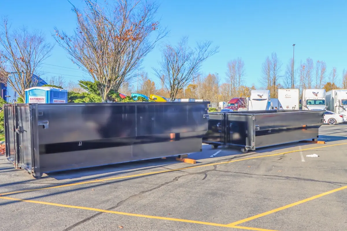 Professional dumpster rental service with roll-off container on residential driveway in Woodmere